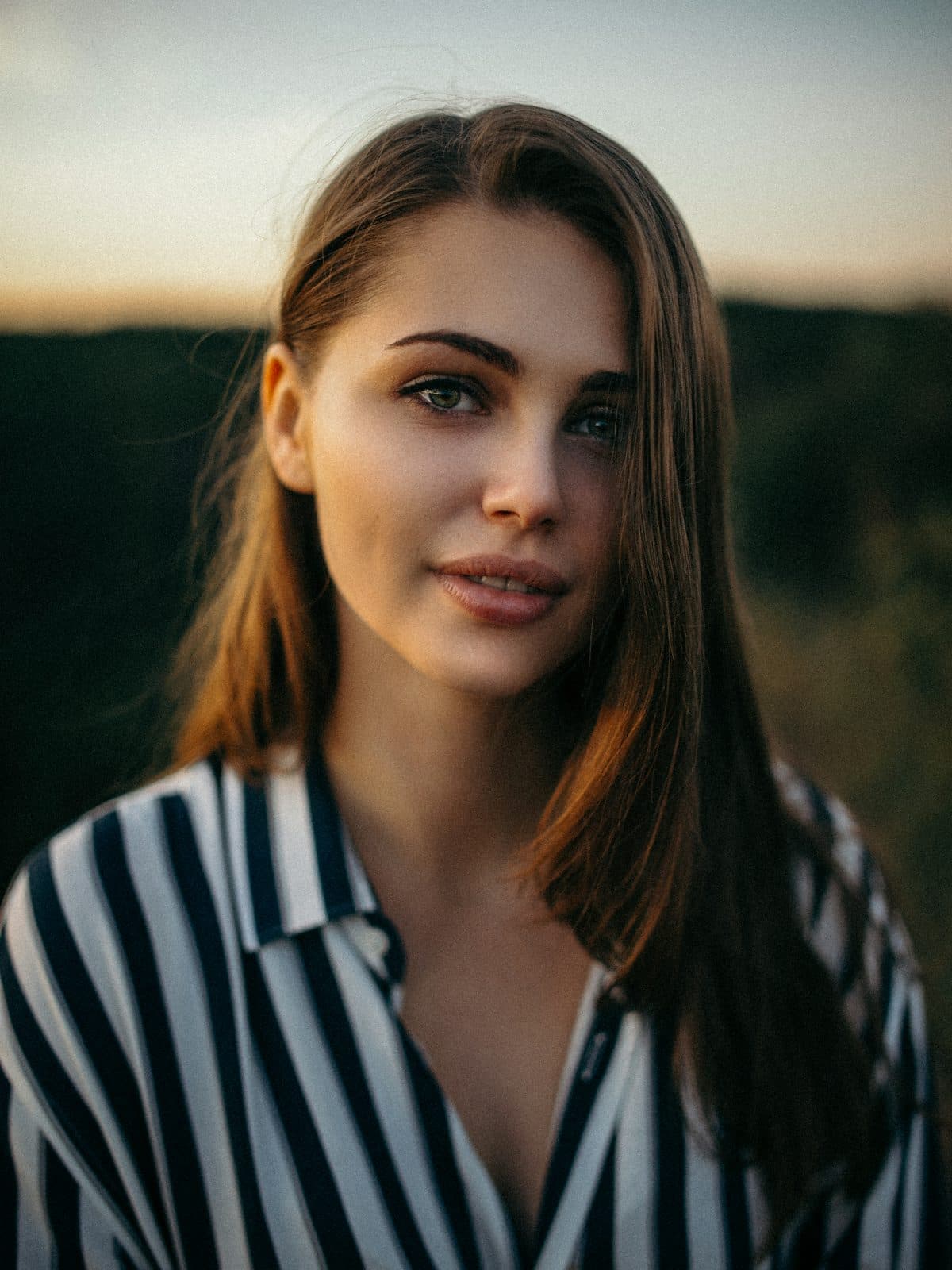 Portret kobiety w prążkowanej koszuli w złotym świetle zachodu
