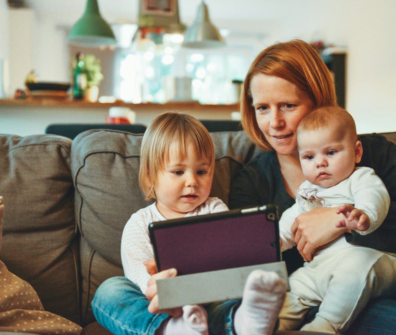 Mama z dwójką małych dzieci na kanapie podczas sesji domowej